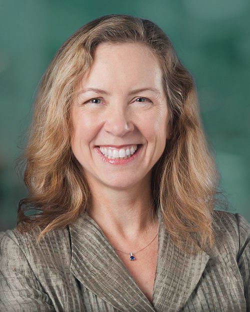 Portrait of Karen Lowry Miller wearing a shimmering, tan-striped coat